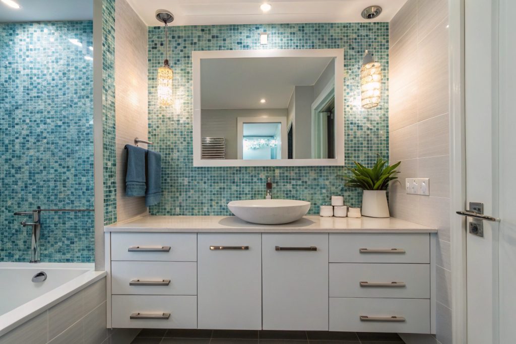 Gradient blue mosaic tile splashback behind bathroom vanity